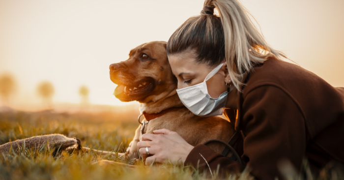 Woman with mask and a dog.